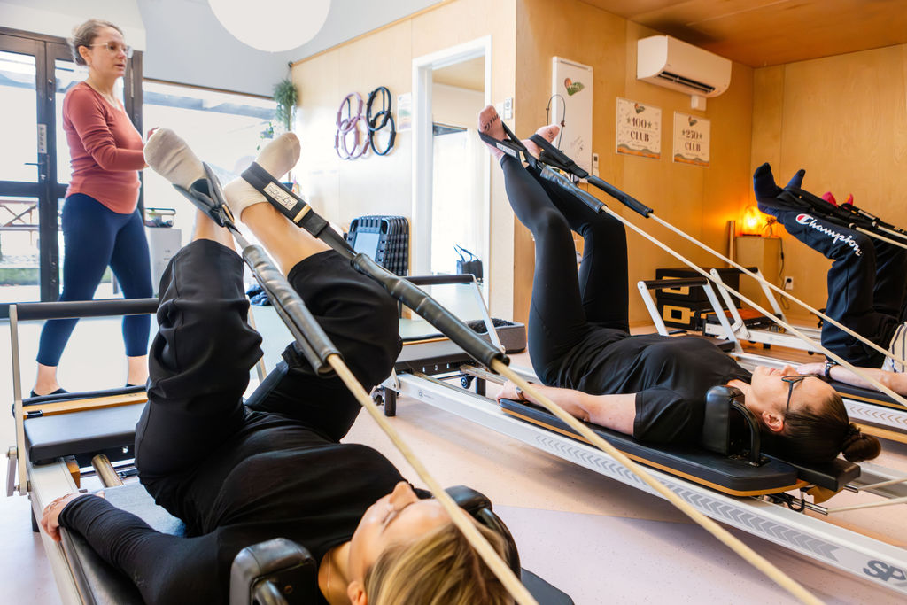 Clients on reformers with instructor guiding the class