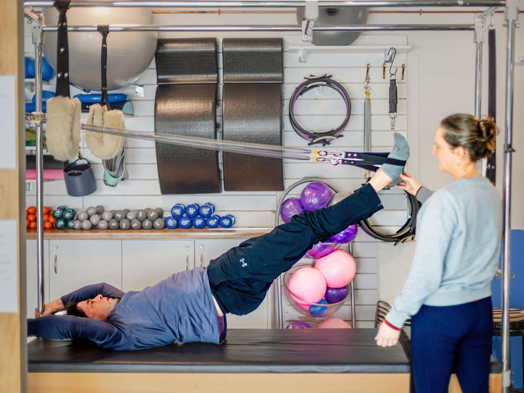 Instructor assisting a client on the trapeze table